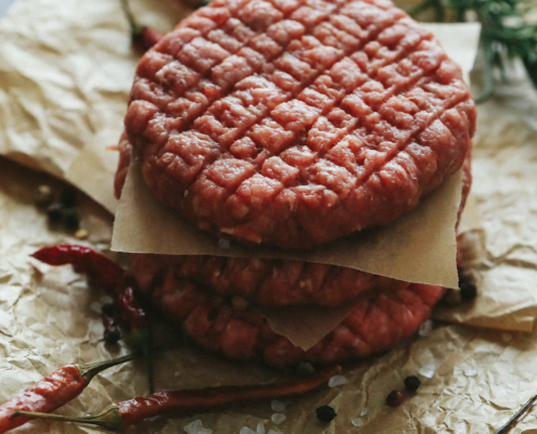 raw-beef-hamburger-patties-with-herbs-spices-dark-slate-plate